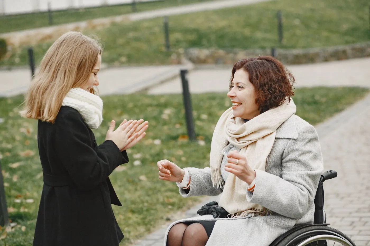 A support worker laughing with a young person outdoors